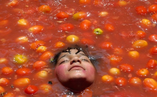 A child rests inside tomato pulp as part of the celebration of Holi in Hyderabad India on February 28 2010