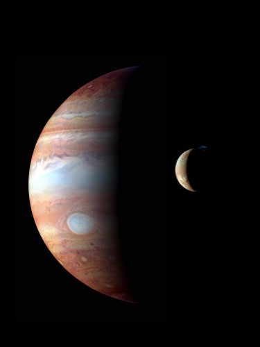 Jupiter and its moon Io. The red dot is a volcano on the moon's surface and the blue cloud is the volcano's emissions