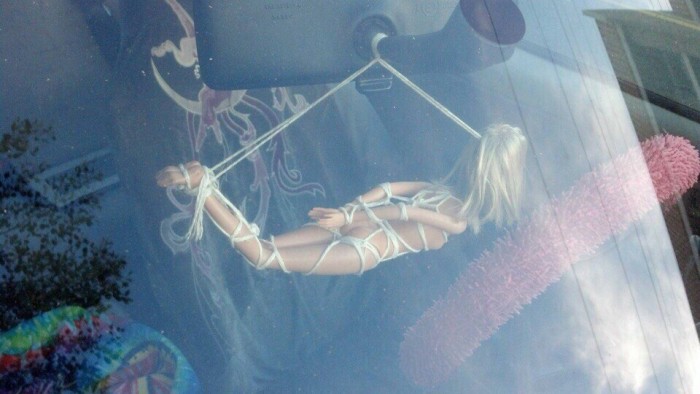 Bondage Barbie hanging from a car.jpg